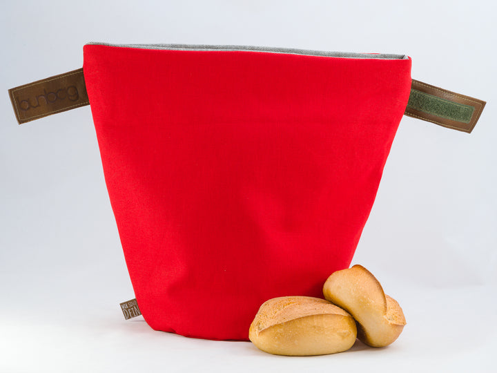 Bunbag „Rote Wonne“: Brötchentasche in Rot, offen, davor Brötchen